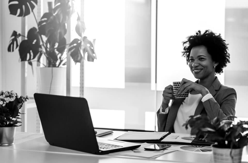 black and white photo of a woman in front of a laptop