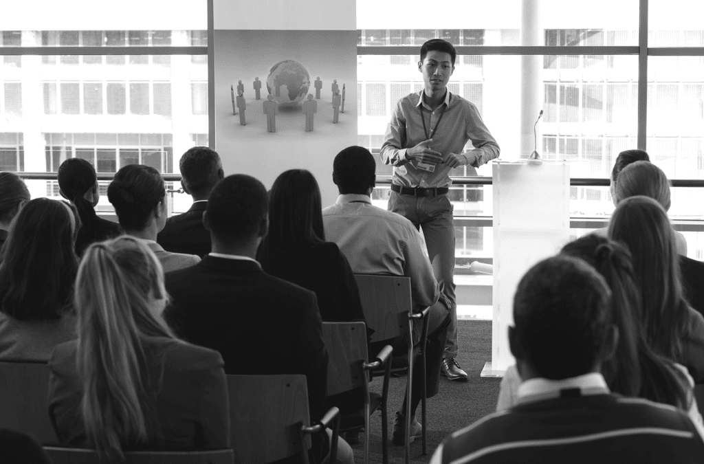 a man standing discussing to a group of seated people