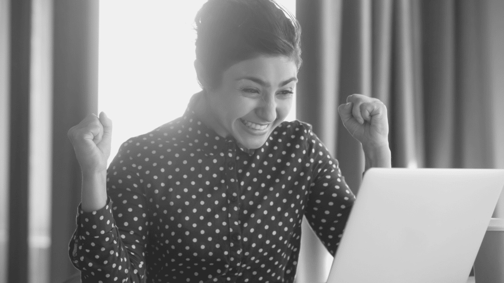 woman smiling in front of a laptop